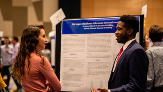 undergraduate students presenting research at NCUR