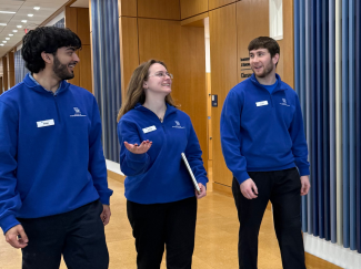 2026 URA Mani Shahzad, Katie Christensen, Austin Trotter walking and conversing in the UK Law Building hallway