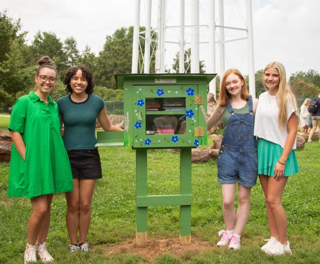 From left to right: Haven Patrick, Maria Wanderley, Rylie Workman, Katie Neglia posing with their green little library box at UK Arboretum.